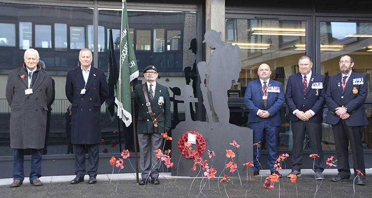 Veterans in front of poppy display